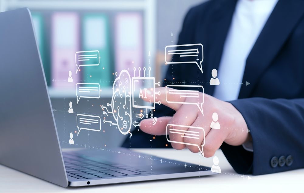 A suited individual uses a laptop featuring icons related to artificial intelligence.