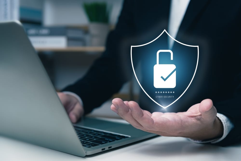 A businessman using a laptop displaying a padlock icon, symbolizing security and data protection.