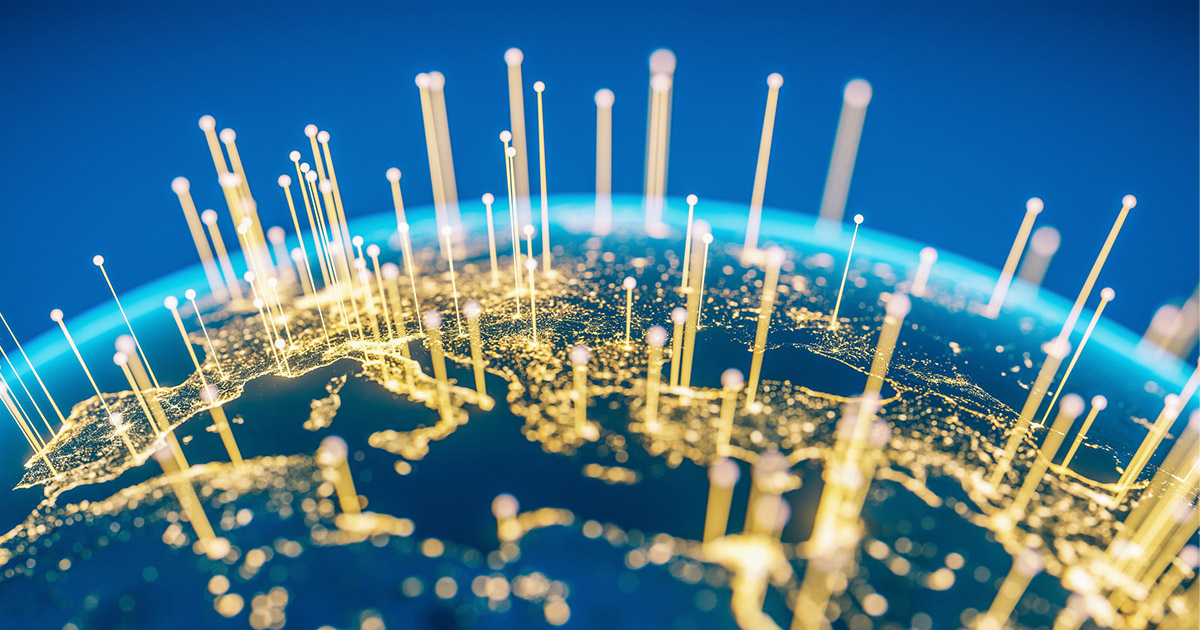 A global view of Earth illuminated by light beams and interconnected networks, symbolizing connectivity and technology.
