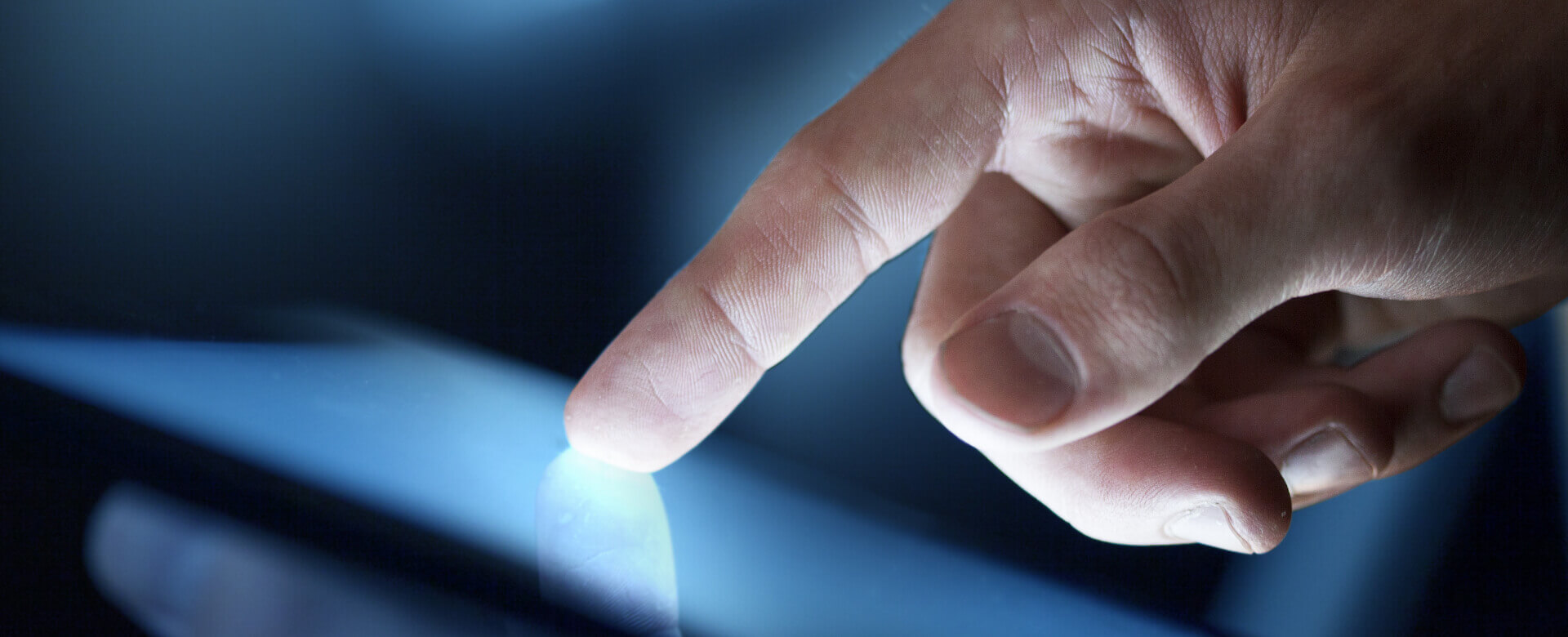 A person using their finger to interact with a tablet computer screen.