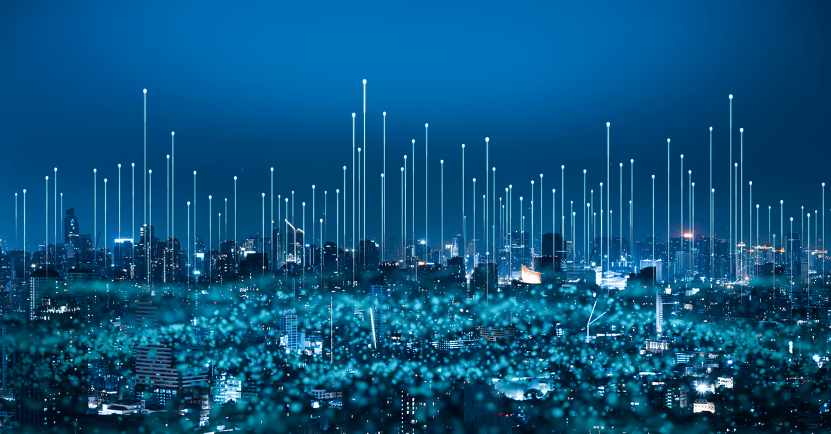 A city skyline glowing with lights, depicting a vibrant and energetic nighttime scene.