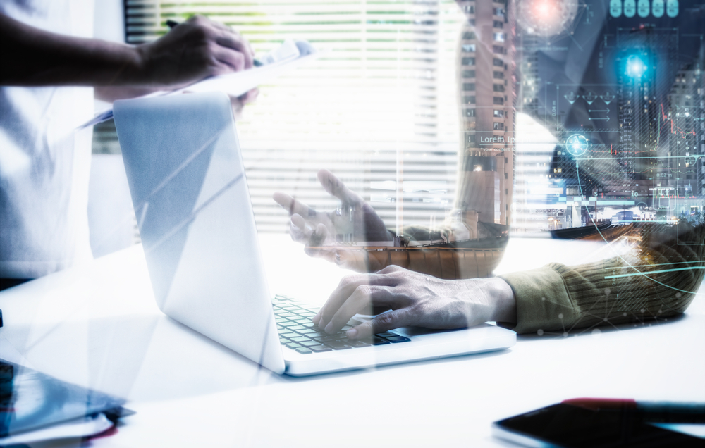 Individual using a laptop, with a bustling cityscape behind them.