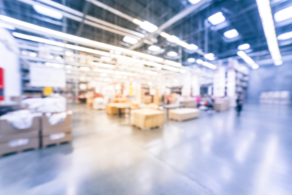 A blurred view of a warehouse showcasing shelves lined with boxes, emphasizing the storage environment.