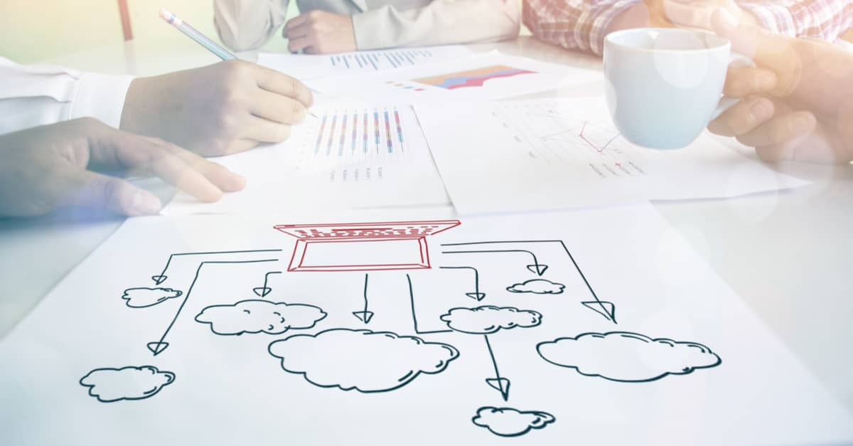 Business professionals collaborating on a white paper, illustrating cloud computing concepts and strategies in a modern workspace.