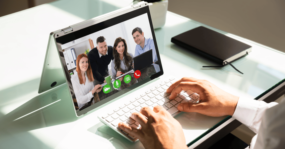 Individual participating in a video call on a laptop, attentively communicating with others on the screen.
