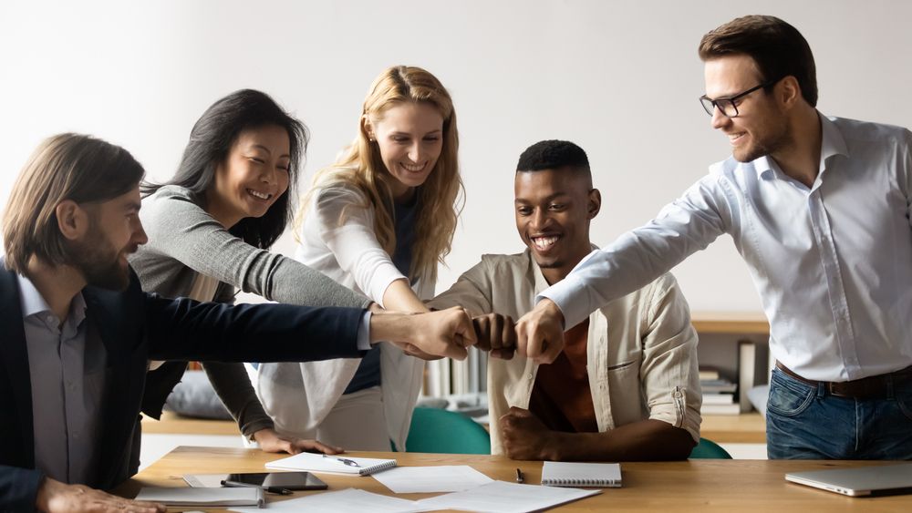 Business professionals shaking hands in a meeting, symbolizing agreement and collaboration.