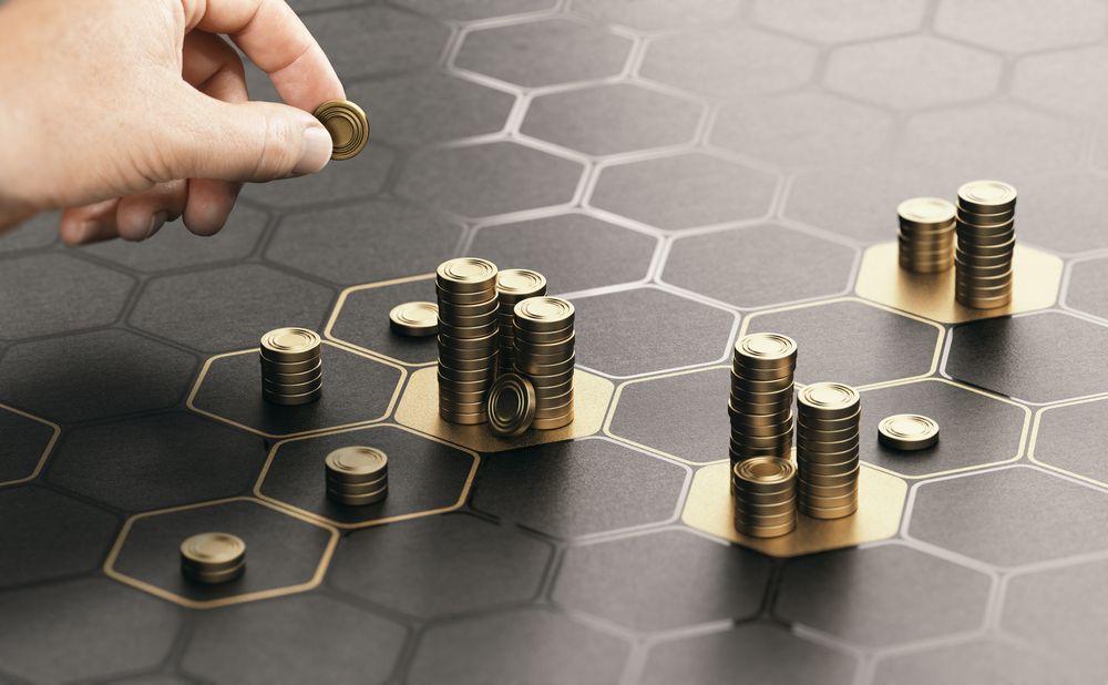 A hand places coins on a hexagonal pattern, emphasizing the arrangement and interaction of the objects.